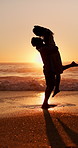 Sunset, silhouette and couple hugging on beach for love, bonding and romantic holiday together. Happy, space and shadow of man embracing woman by ocean on seaside vacation, getaway or weekend trip.