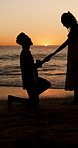 Sunset, engagement and silhouette of couple on beach for romantic holiday, getaway or vacation. Love, shadow and man with woman for marriage proposal by ocean for commitment, care or connection.