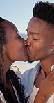 Couple, hug and love at beach, kiss and laughing with partner for anniversary celebration or holiday. Outdoor, black people and embrace with spouse on special event, bonding and support on vacation