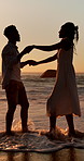 Holiday, sunset and couple with dancing in sea for bonding, romantic getaway and travel for connection. Ocean, support and people with tropical vacation for relationship, love and moving together
