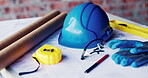 Construction, helmet and blueprint with tools on table, infrastructure schematic or safety equipment. Building plan, scale or ppe for renovation project, tape measure or gear for property development