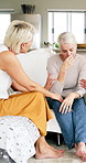 Senior, women and crying with friends for support, compassion and understanding for grief in home. Sad old person, tears and bad news in living room with caring friendship, solidarity and empathy.