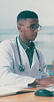 Computer, glasses and healthcare with doctor black man in hospital for agenda, planning or writing. Notebook, research and typing with medical professional at desk in clinic for online calendar