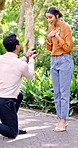 Engagement ring, propose and surprise with couple in park together for love or milestone. Commitment, question and wow with happy people outdoor for bonding, marriage promise or unexpected moment