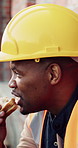 Builder, man and lunch at construction site with break, sandwich and smile for building renovation. Black person, eating food and worker rest outdoor with industrial job, PPE and thinking for work.