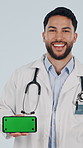 Face, phone and happy doctor with green screen, medical promo and insurance marketing in studio. Show mobile, man and healthcare worker with mockup space, laugh or telehealth ads on white background