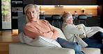 Elderly, couple and ignore with separation on sofa for argument, fight or conflict together in home. Senior, man and frustrated woman with arms crossed for disagreement, toxic marriage or dispute