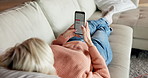 Typing, phone screen and relax with old woman on sofa for social media, ebook subscription and email. Online library, comfort and mature person in home, tech for communication and message to contact