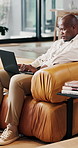 Relax, laptop and black man on sofa in home with reading ebook, blog or post on social media in living room. Calm, computer and African male person with online newsletter with typing in apartment.