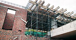 Scaffolding, construction or empty site with brick wall for building progress, renovation or jobsite. Low angle, masonry structure and remodeling project for house expansion, maintenance or framework