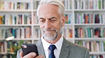 History, phone and scroll with man in library for archives, book collection or research. App, information and texting with mature historian in bookstore for fact finding or verification on mobile