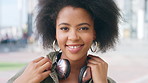 Face, headphones and black woman in city, funny and confidence with fashion, trendy and laugh. Outdoor, African person and listening to music, sound and digital app for audio, radio and technology