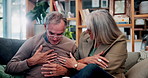 Home, chest pain and senior couple with heart attack, stress or health emergency in retirement. Elderly man, woman and cardiovascular problem in living room, medical discomfort and worry for illness