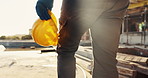 Person, architect and walking with helmet on construction site for building safety, PPE or security. Back view, contractor or civil engineer with hard hat for architecture rules or regulations