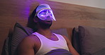 Man, skincare and blue light mask in bed for acne treatment, reduce inflammation and relax at night. Late, person rest and LED tech in home for dermatology, skin oil regulation or anti aging benefits