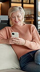 Funny, phone and relax with old woman on sofa in home living room for social media browsing. App, text message and typing with senior person laughing in apartment for break, retirement or wellness