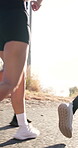 Exercise, legs and running with people outdoor on road together for marathon or training. Cardio, fitness and sports activity with runner group on path in nature for action, pace or workout routine