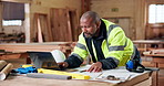 Architect, laptop and black man with documents in woodshop for carpentry construction or production. Male person, contractor or carpenter designer with computer for timber project or lumber business