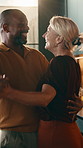 Dancing, couple and holding hands with smile in home for music, bonding or romance together. Interracial people, man and woman with happy partner, twirl or hug for vibe, love or trust in kitchen