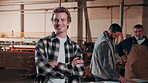 Carpentry, face and man in workshop with crossed arms, manufacturing and wood production. Laugh, carpenter and portrait of person with team for timber business, furniture restoration and woodworking