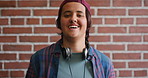 Face, laugh and student by brick wall with headphones for music education or future development. Portrait, teenager and funny boy with audio tech for academic podcast, scholarship and background