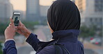Travel, photo or Muslim woman in city with phone screen, online memory or sightseeing post on weekend. Digital, back or Arab person with tech, social media update or town capture on tourist trip.
