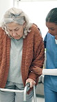 Women, nurse and senior with walker in home for assisted living, healthcare or physiotherapy. Female people, caregiver or helping patient with walking aid for mobility, elderly care or rehabilitation