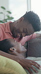 Smile, relax and couple on couch with love, affection and bonding together in living room. Happy, black people and cuddle at house with kiss, romantic partner and healthy relationship for commitment