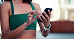 Phone, fitness and hands of woman in city with typing for texting, social media or chatting. Athlete, technology and female person scrolling on app for workout program on cellphone in urban town.