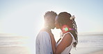 Kiss, love and black couple by beach in holiday, getaway or weekend trip together for bonding. Happy, space and African man with woman for intimate moment in marriage by ocean for seaside vacation.