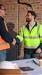 Architect, handshake and men with blueprint in building, team and planning for property development. Civil engineer, talking and shaking hands for architecture project, happy and people with document
