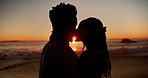 Kiss, sunset and silhouette of couple by beach in holiday, getaway or weekend trip together for bonding. Happy, shadow and man with woman for intimate moment in marriage by ocean for seaside vacation