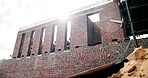 Outdoor, construction or empty site with brick wall for building progress, renovation or scaffolding. Masonry, residential structure and upgrade project for house expansion, maintenance or framework