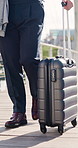 Business travel, legs and hand with suitcase in city, walking and lawyer on urban street or journey. Outdoor, attorney and person with international career opportunity, feet and commute with luggage