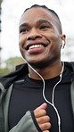 Fitness, man or running with earphones at park for exercise, pace training or music playlist. Runner, happy black person or workout outdoor with audio streaming, sports performance or jogging routine