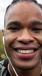 Fitness, face and black man with earphones in rain for exercise dedication, morning cardio and laugh. Wet, athlete and happy outdoor for winter wellness, health discipline or streaming music playlist