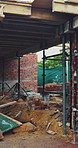 Exterior, scaffolding and empty site for construction, foundation and building framework. Metal, wooden beam and material with structure support, urban development and civil engineering for expansion