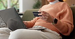 Laptop, typing and woman on sofa with credit card, online shopping and purchase on website store. Hands, home and person on computer for digital banking, virtual payment and transaction for ecommerce