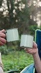 Men, hands and cheers with coffee for camping, bonding and relax in nature environment to celebrate. Senior father, son and toast with tea on holiday, vacation or trip in woods with love and care