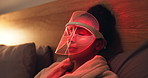 Red light, relax and woman with mask for skincare, beauty or wellness with collagen production. Health, cosmetic and female person on bed with facial glow therapy for dermatology treatment in home.