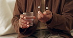 Water, pills and hands of person in house for medical treatment, prescription and tablets for recovery. Healthcare, man and medication in living room for vitamins, supplements and drugs on sofa