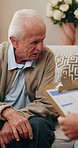Senior man, help and talk with psychologist in office, therapy session and mental health evaluation. Therapist, consultation and elderly person with depression, writing and assessment with clipboard
