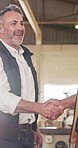 Carpentry, handshake or man in factory with inspection, building deal or hello in safety check. Flare, happy or mature carpenter with shaking hands, partnership greeting or approval in compliance.