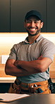 Arms crossed, face and smile of plumber man in kitchen of home for maintenance or repair success. Confidence, installation and tool belt with happy person in apartment for plumbing or renovation