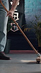 Sweeping, cleaning and person in tattoo parlor for maintenance, chores and responsibility in store. Creative, small business and man with broom for dust prevention, hygiene and mess in ink shop