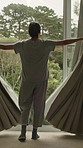 Window, open and back of woman in home to start day, morning routine and sunlight. House, accommodation and person with curtains for view, sunshine and nature for fresh air, wellness and weather