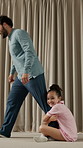 Leg, clinging and dad with child in house, playful resistance and connection with parent on weekend. Walking, man and seeking attention from father, happy girl and family attachment on break in home