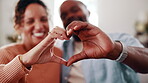 Couple, heart hands and bonding with smile in home, together and connection with partner on weekend. Interracial, relationship and happy people with love symbol, romance and finger shape in house