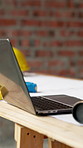 Blueprint, architecture and laptop on construction site for property, PPE or building plan. Project, documents or paperwork with floor layout or tech for civil engineering design or infrastructure