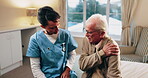 Talking, caregiver and shoulder pain of senior man in home for healthcare, elderly support or wellness. Retirement, nurse and old person with patient care, homecare and stiff joint with arthritis